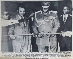 President Amin cuts the tape to officially open the Libyan Arab Uganda Bank for Foreign Trade and Developmet. On the left is Mr Abudulla A. Saudi, Chairman and General Manager of the Bank; and extreme left (with glasses) is Mr Clhadi M. Algaghih, the Bank's Managing Director. On the right is Uganda's Minister of Finance, Planning and Economic Development, Mr. E.B. Wakhweya.' Uganda Argus, January 25th 1973